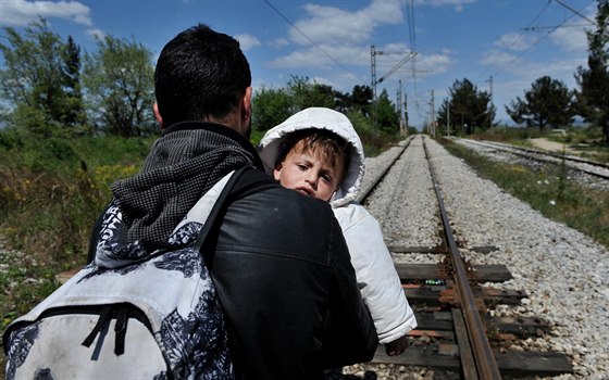 Uprchlík s díttem kráí po eleznici na hranici ecka a Makedonie (21. dubna...