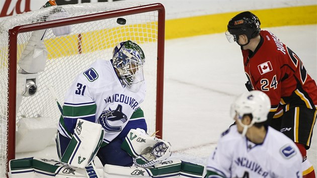 Ji Hudler z Calgary sleduje puk letc za zda vancouverskho branke Eddieho Lcka.