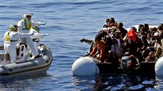 Italští policisté se blíží ke člunu s africkými uprchlíky nedaleko libyjského... Italští policisté se blíží ke člunu s africkými uprchlíky nedaleko libyjského...