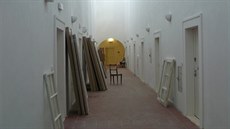 Snímek zachycuje chodbu s mniskými celami, kde vznikají pokoje pro hosty.
