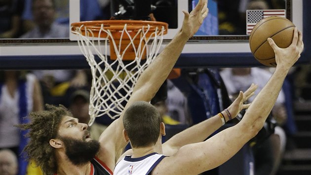 Marc Gasol (vpravo) z Memphisu zakonuje pes brncho Robina Lopeze z Portlandu.