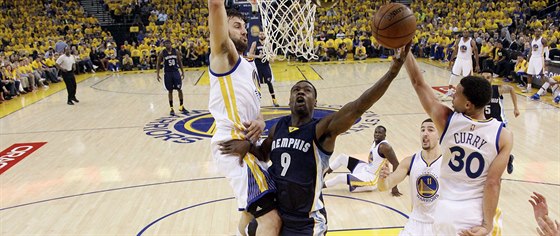 Tony Allen z Memphisu (v tmav modrém) se tlaí k zakonení, brání ho dva...