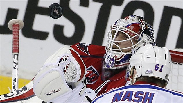 Washingtonsk glman Braden Holtby chyt puk ped Rickem Nashem z NY Rangers.