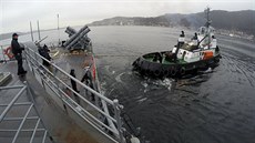 Remorkér pomáhá USS VICKSBURG vyplout z norského pístavu Bergenu