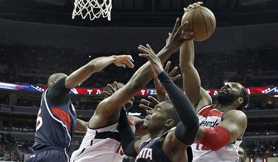 Urputný boj pod koem v zápase Washington - Atlanta. Zleva Al Horford z...