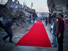 PIPOMÍNKA VÁLKY. Palestinci pokládají ervený koberec mezi trosky dom, které...