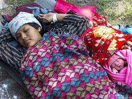 Maya Tamang, 20, sleeps next to her one-day-old daughter at a makeshift...