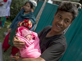 Buddha Tamang, 21 holds his one-day-old daughter at a makeshift shelter...