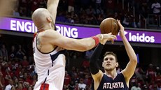 Mike Muscala (vpravo) z Atlanty stílí pes Marcina Gortata z Washingtonu.