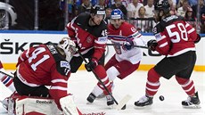 PEVNÁ OBRANA. Kanadský gólman Mike Smith pozoruje poctivou obrannou činnost... PEVNÁ OBRANA. Kanadský gólman Mike Smith pozoruje poctivou obrannou činnost...