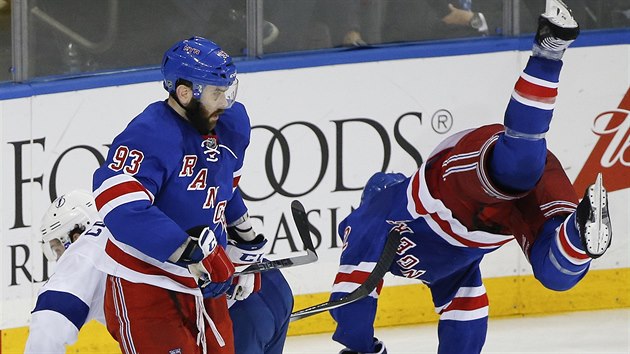 Obrnce Dan Boyle (vpravo) z New York Rangers let vzduchem po stetu s Ryanem Callahanem z Tampy Bay. Jak tvrd bude jeho dopad na led sleduje spoluhr Keith Yandle.