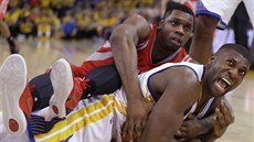 Souboj o mí v podání Festuse Ezeliho (dole) z Golden State a Terrence Jonese z...