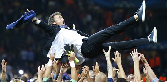 Luis Enrique, trenér fotbalist Barcelony, nad hlavami hrá po vítzném finále...