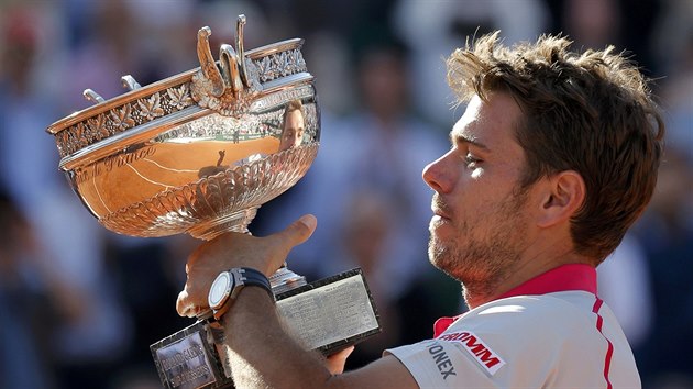 Stan Wawrinka si okouzlen prohl trofej pro ampiona Roland Garros, kterou za chvli zvedne nad hlavu.