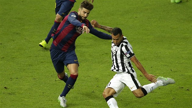 Carlos Tvez (vpravo) z Juventusu hodl centrovat, zabrnit mu v tom chce Gerard Piqu z Barcelony.