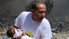 Mu odnáí dít z místa výbuchu v Aleppu. Vojska prezidenta Baára Asada...