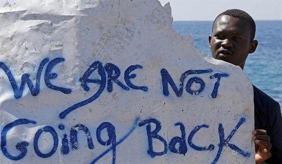 Uprchlík drí nápis Vracet se nebudeme poblí hranic mezi Itálií a Francií...