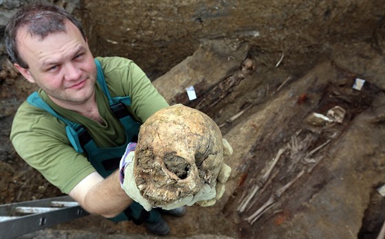Archeolog Michal Beránek ukazuje enskou lebku z archeologické sondy v...