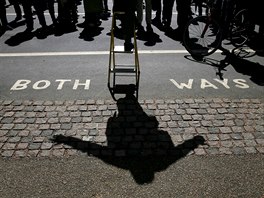 A speaker casts a shadow on the ground as he addresses a crowd at Speakers'...