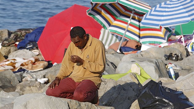 Uprchlk se modl pobl hranic mezi Itli a Franci (19. ervna 2015).
