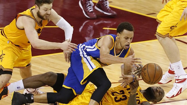 Stephen Curry z Golden State unik, lec LeBron James a Matthew Dellavedova z Clevelandu se ho pokouej zastavit.