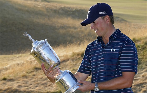 Americký golfista Jordan Spieth si prohlíí trofej pro vítze US Open.