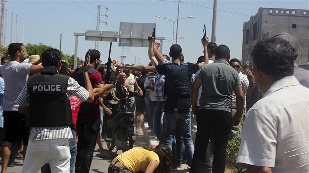 Tunisk policie ukliduje dav lid, kte prchaj ped stelbou na pli ve mst Sousse (26. ervna 2015)