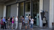 Lidé se shromaují u bankomat, aby si vybrali 60 euro, které jim vláda denn...
