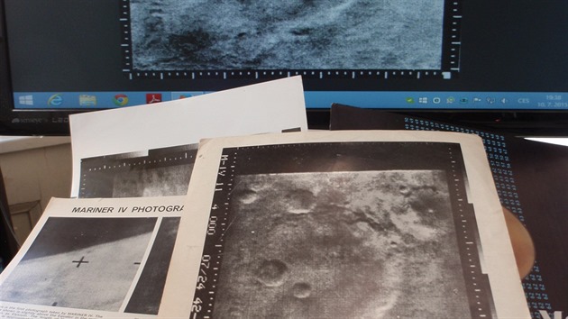 Fotografie, publikace a osobn dopisy po plstolet opt na pracovnm stole Pavla Toufara. V pozad historick foto Marsu z roku 1965 na monitoru potae.
