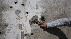 Nedzad Avdi se dotýká stny na bývalém popraviti nedaleko základní koly ve...
