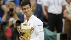 Novak Djokovi hrd pózuje s trofejí pro vítze Wimbledonu.