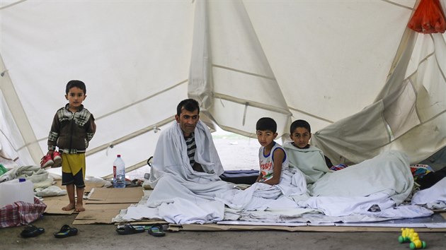 Rodina uprchlk sed ve stanu ped recepc centra pro uprchlky v Berln (22. ervence 2015).
