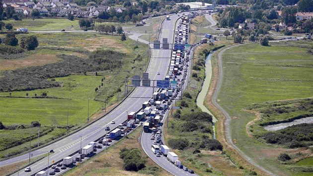 Kolona na francouzsk dlnici ped terminlem Eurotunelu. Stojc a popojdjc kamiony jsou pro migranty vtanm clem (28. ervence 2015)