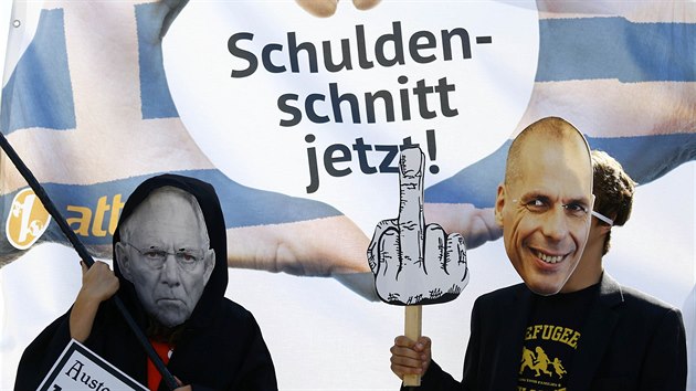 Demonstranti s maskami ministr Schubleho (vlevo) a Janise Varoufakise.
