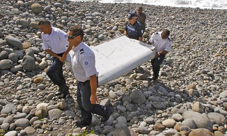 Policisté odnáejí ást letadla na ostrov Réunion (29. ervence 2015).