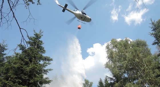 Vrtulník shodil do hoícího lesa u Mdnce patnáct dávek vody (8.srpna 2015).