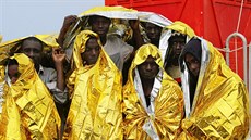 Migrants wait to disembark from a Coast Guard ship in Sicilian harbour of...