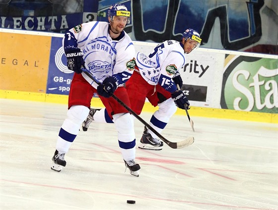 Hokejisté Komety Brno zakládají útok v utkání se Slovanem Bratislava.