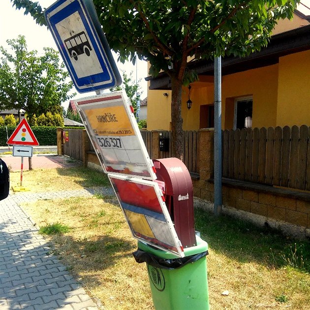 Vandalové penesli stojan autobusové zastávky v Hrníích do odpadkového koe.