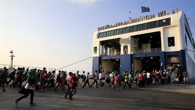 Turisti a uprchlci nastupuj na ootrov Kos na trajekt smujc do Athn (10. 8. 2015)