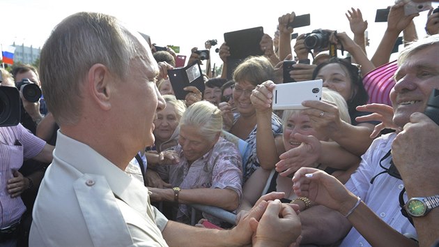 Vladimir Putin se zdrav s lidmi.