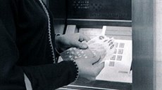 Žena si přepočítává peníze, které právě vybrala z prvního bankomatu na světě.... Žena si přepočítává peníze, které právě vybrala z prvního bankomatu na světě....
