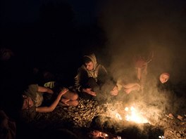 Syrtí uprchlíci se ohívají u ohn nedaleko nádraí Idomeni na severu ecka a...