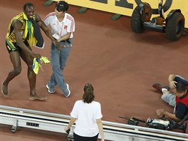 Usain Bolt (vlevo) po srce s nskm kameramanem.