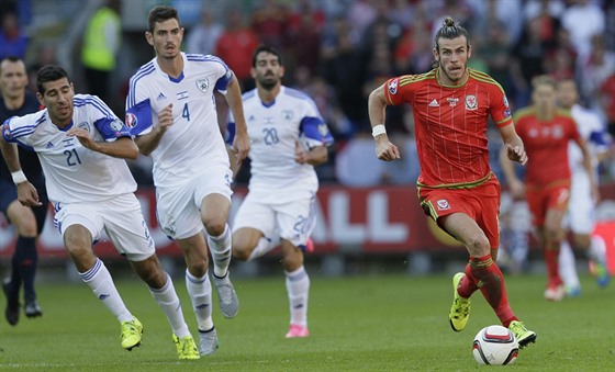 Velský fotbalista Gareth Bale uniká izraelské obran.
