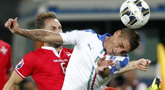 Italský fotbalista Marco Verratti (v bílém) hlavikuje v souboji s Paulem...