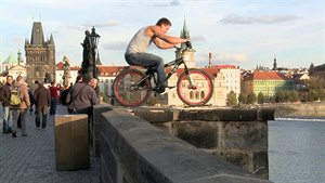 ílenec jezdí po hran Karlova mostu na kole