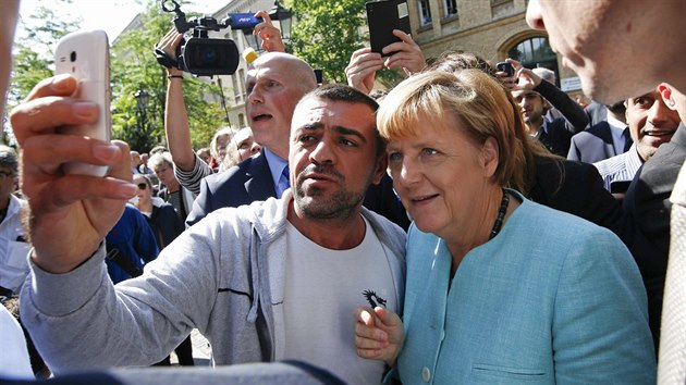 Uprchlci v Berln vtali kanclku Angelu Merkelovou s nadenm. (10. z 2015)