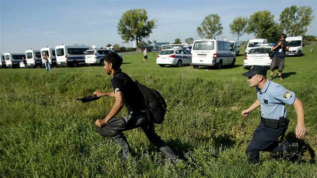 Policista sth migranta u chorvatskho msta Tovarnik. Za posledn den jich ze Srbska pilo pes sedm tisc. (17. z 2015)