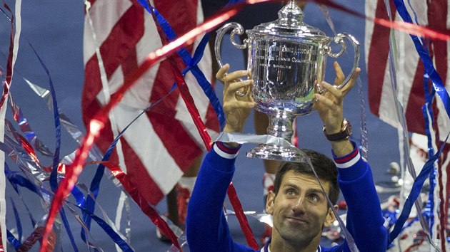 OSLAVA VÍTZE. Novak Djokovi s pohárem pro vítze tenisového US Open v záplav...